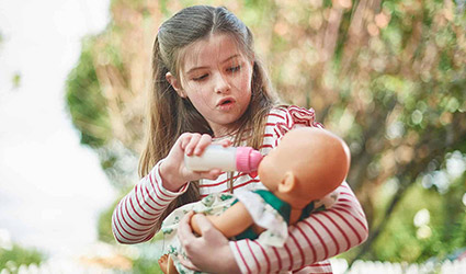 Girl has imaginative play with a doll
