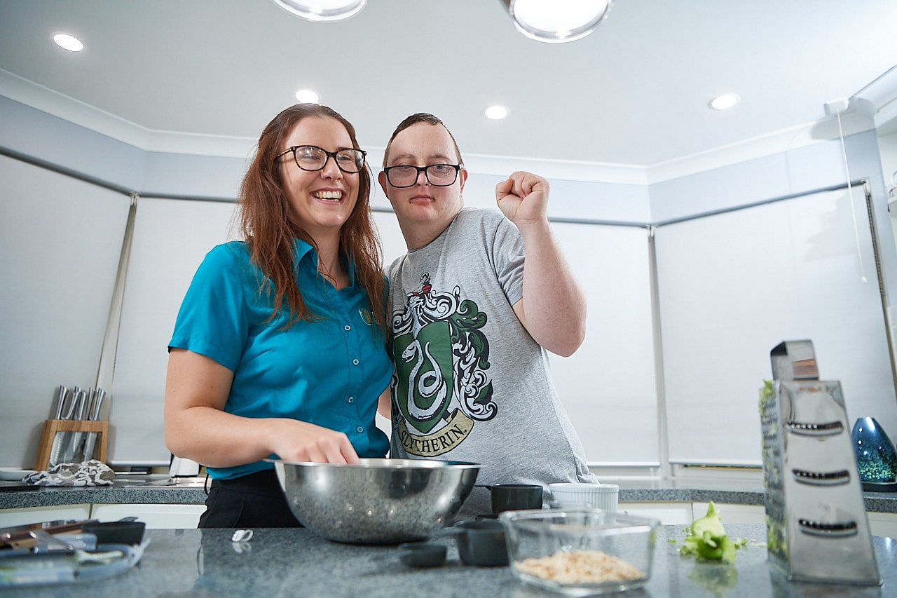 Therapist smiling and cooking with male customer
