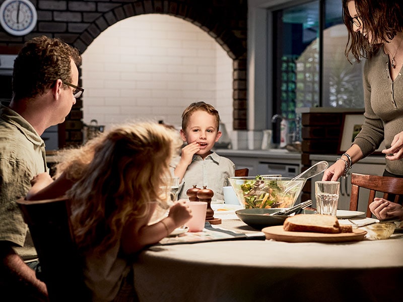 A boy at the dinner table with his family