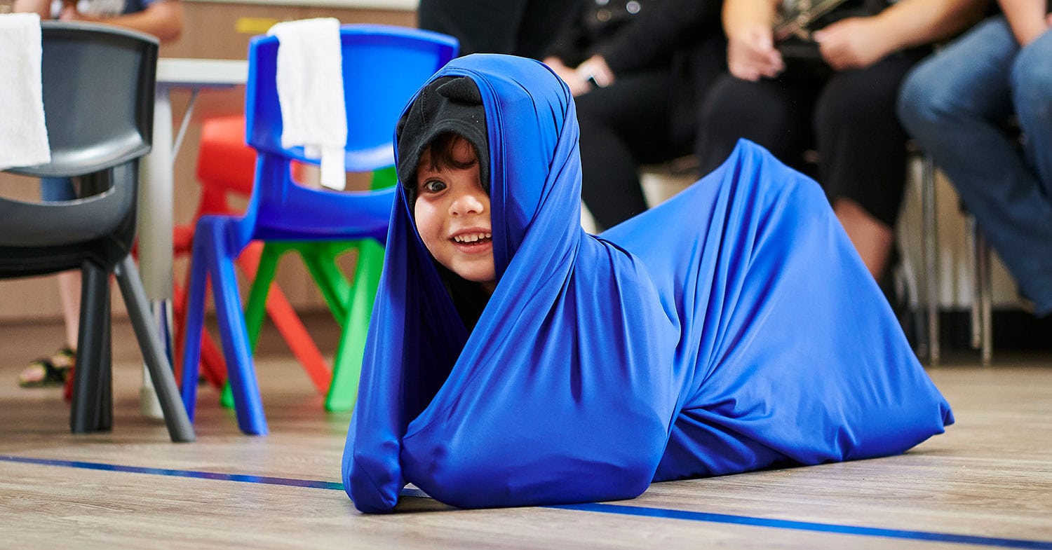 Boy plays in a large piece of cloth