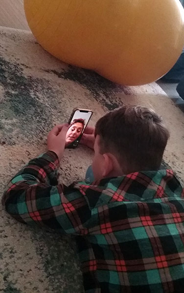A boy speaking to his therapist via FaceTime