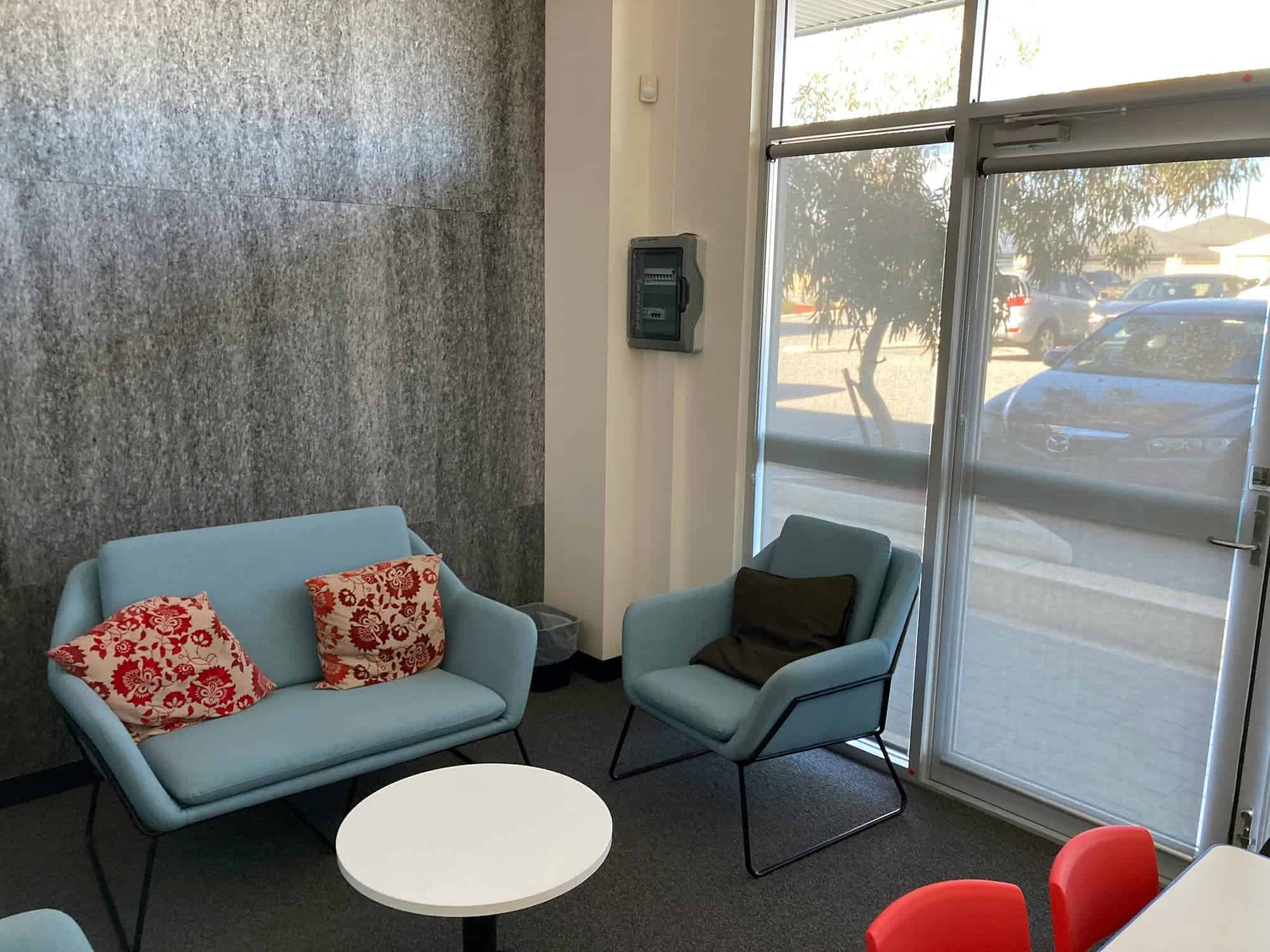 A waiting room with comfortable blue chairs