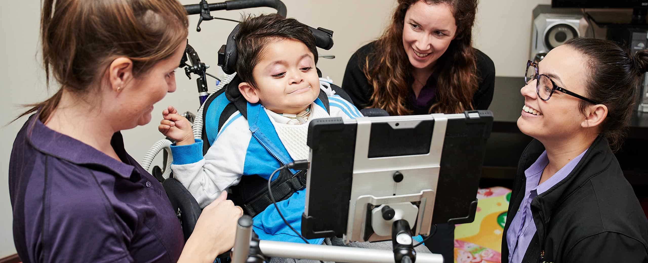 Young boy receiving support from therapists