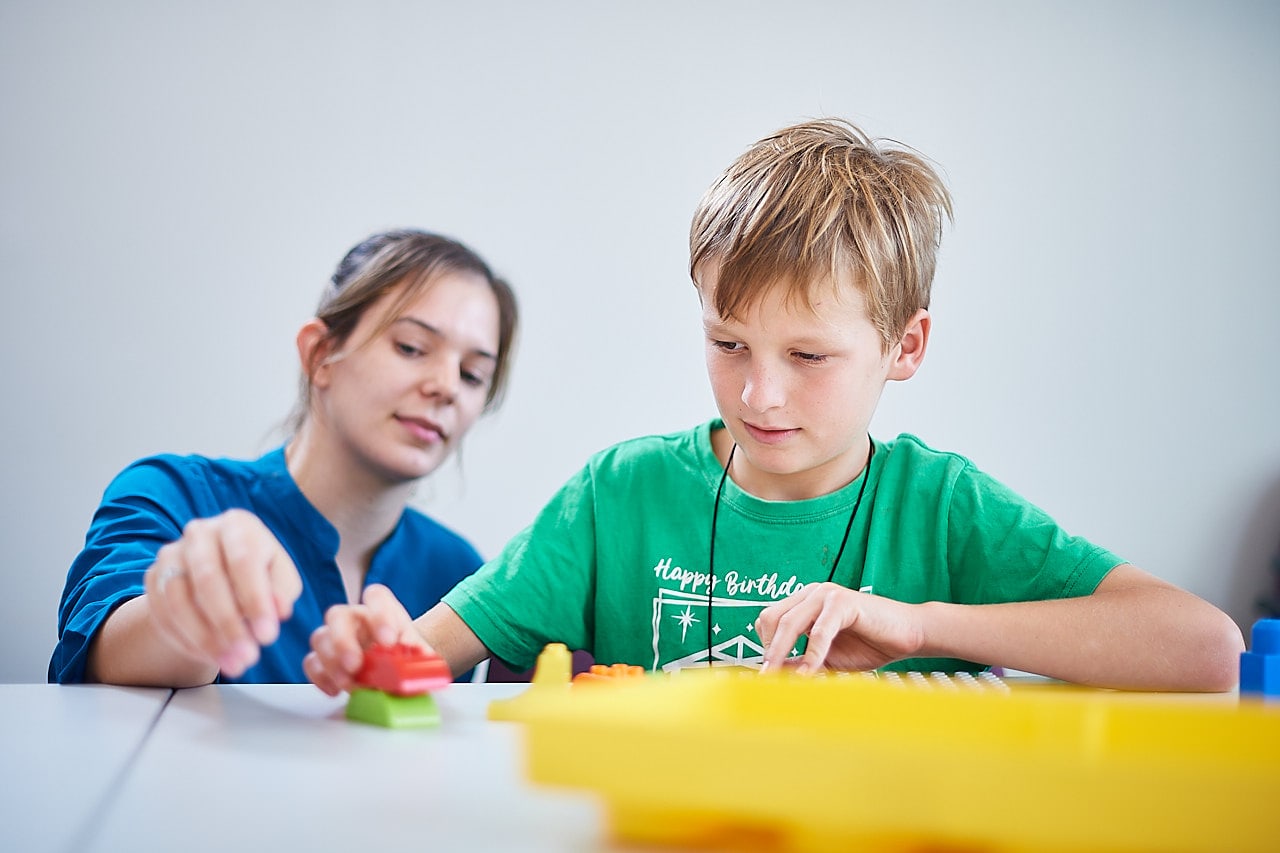 Therapist works with customer in a Lego group