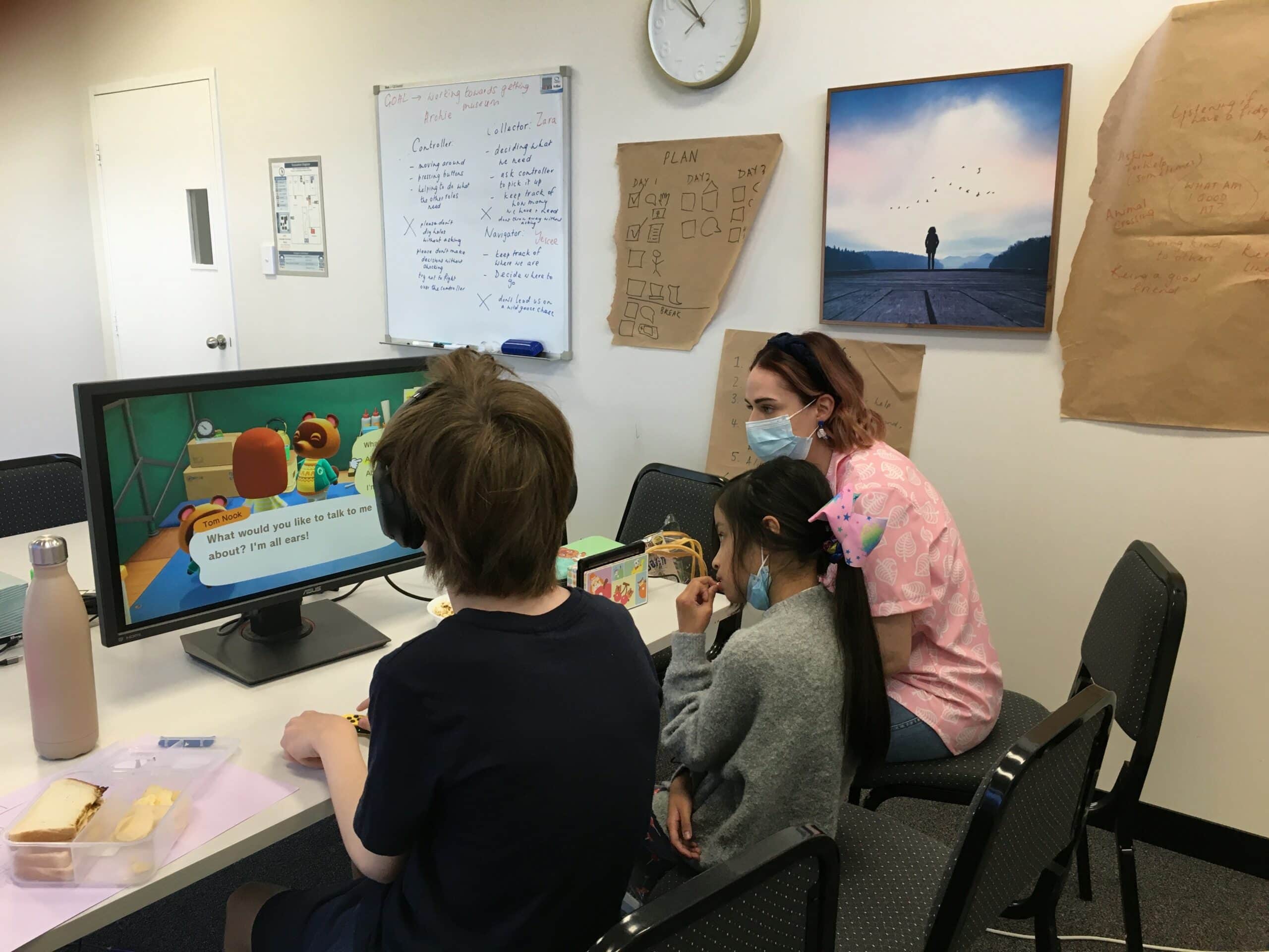 therapist and kids playing animal crossing on the computer