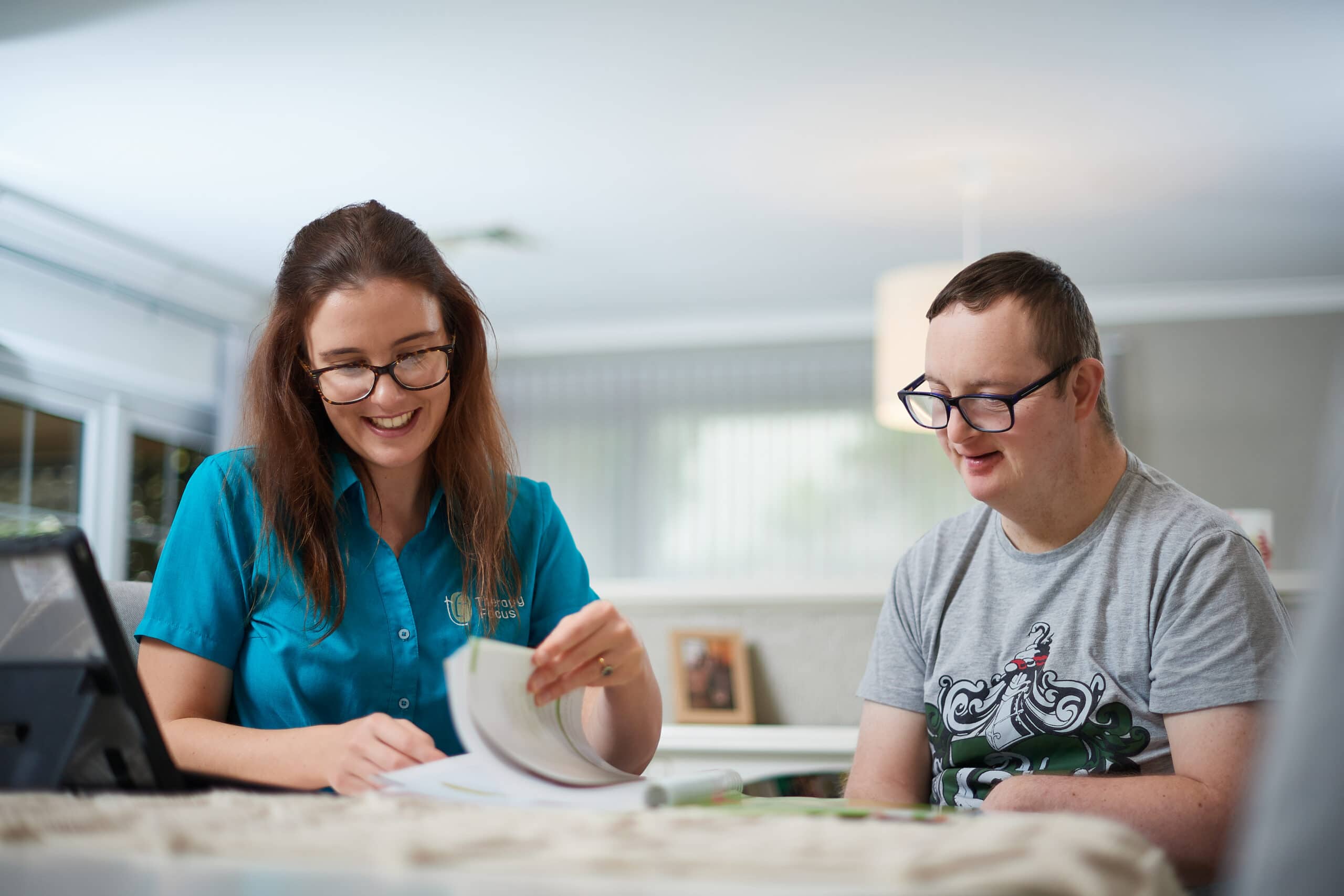 Therapist looking through a book with male customer