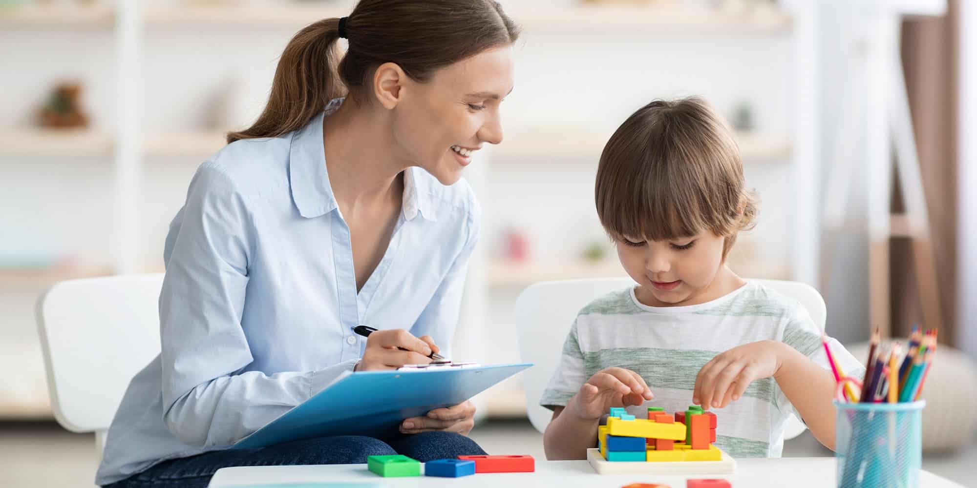 A Therapist with a clipboard watching a child play