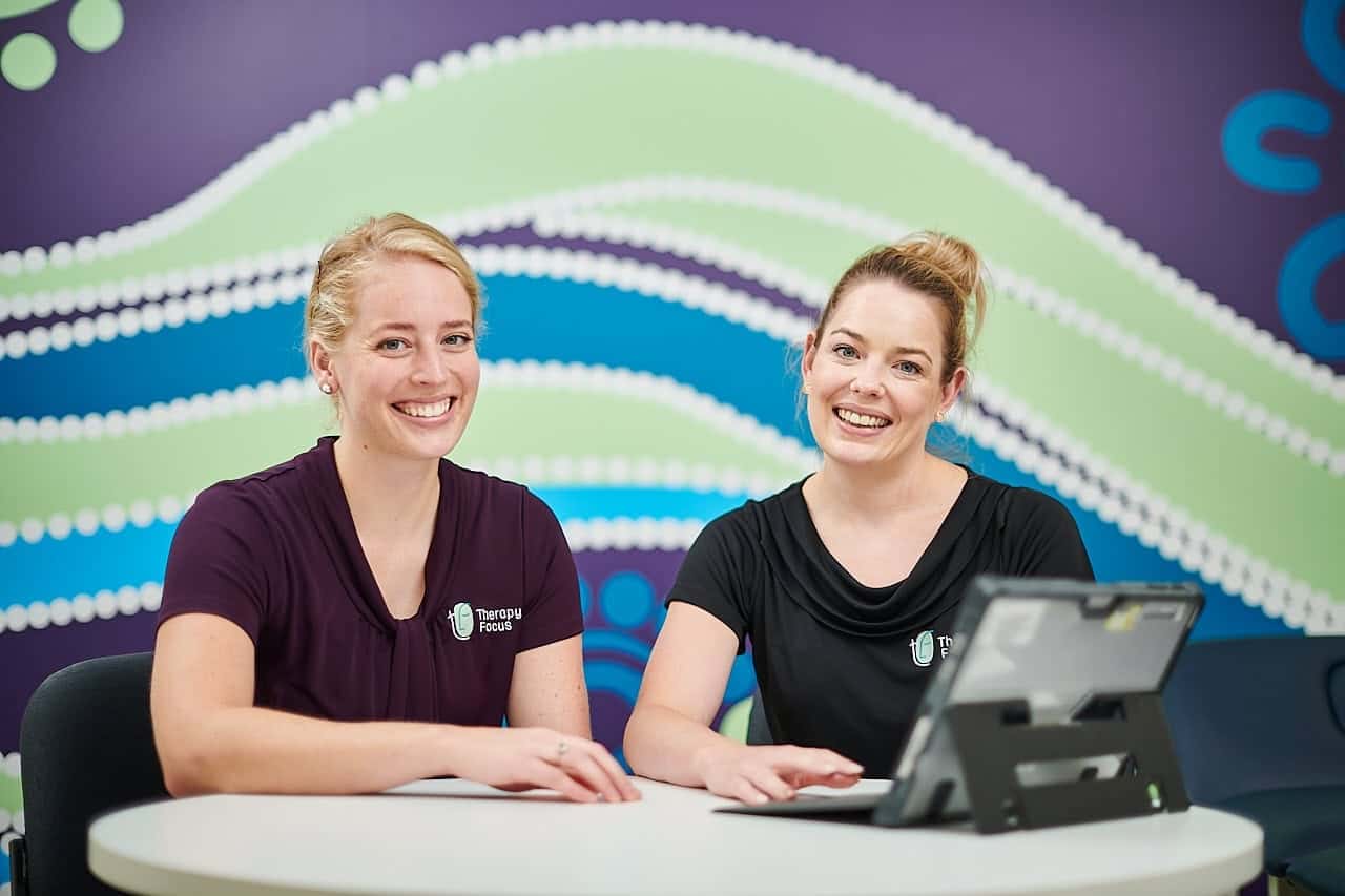 Two female therapists smiling at the camera