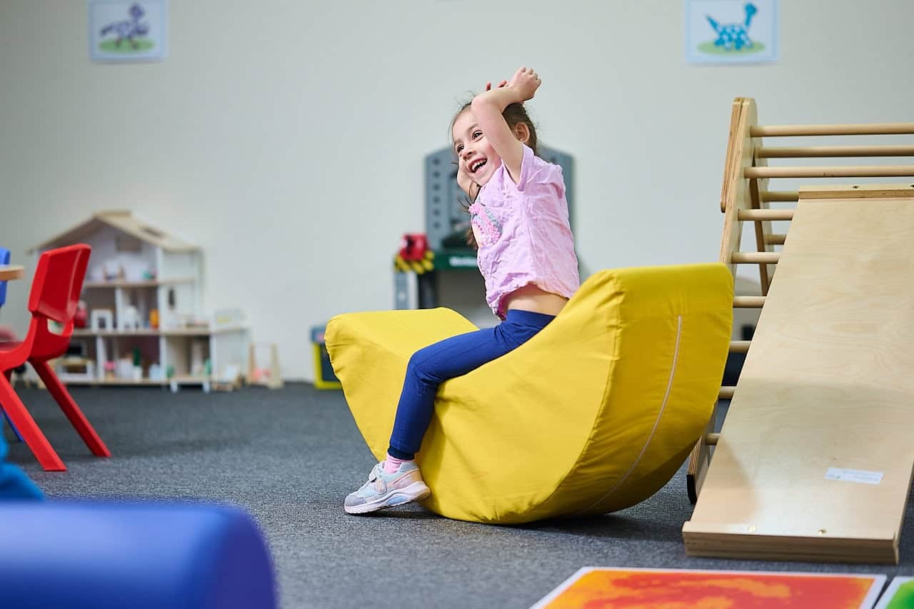 Young girl playing on rocking toy